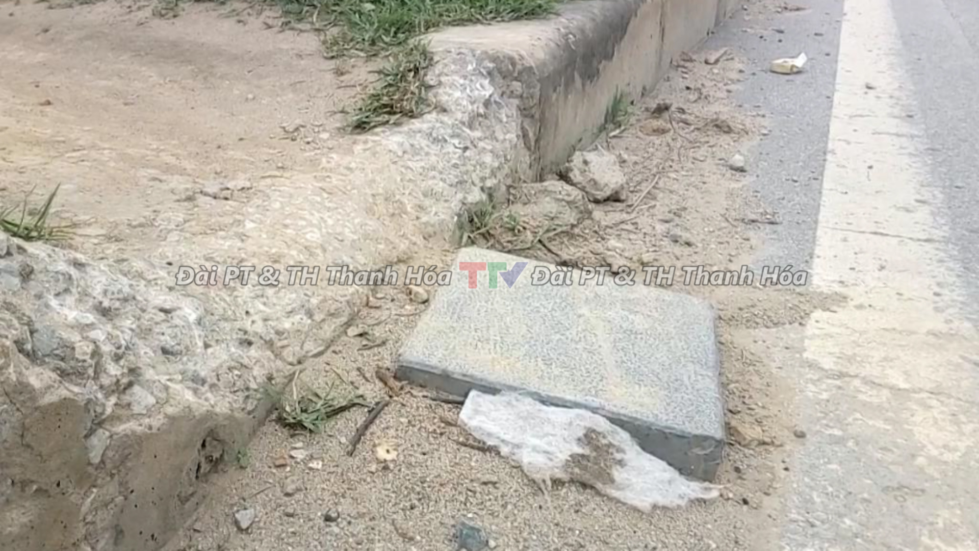 Người dân đặt thêm gạch đá để dễ dàng vượt qua dải phân cách qua Đại lộ Hùng Vương (Quốc lộ 1A)