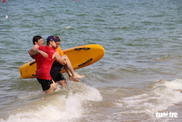 Dùng lướt sóng cứu người và đưa lên bờ - Ảnh: T.THỊNH