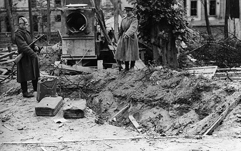 Hai lính Nga chỉ vào chỗ được coi là mộ của Hitler ở phía sau Phủ Thủ tướng Đức Quốc xã ở Berlin. Ảnh: Getty.