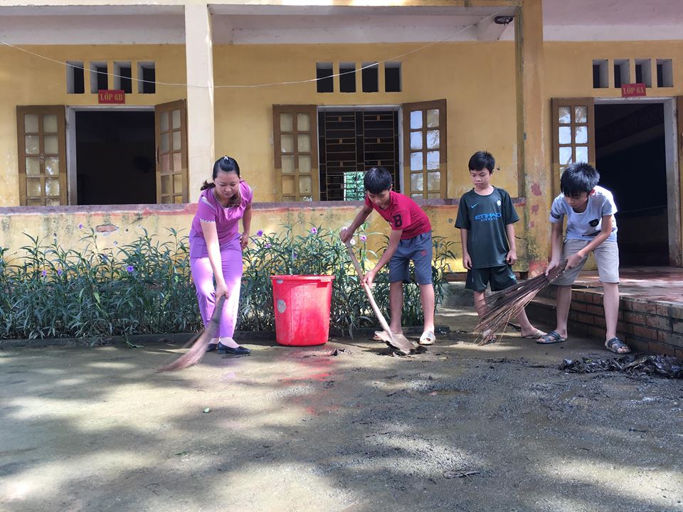 Cô giáo Lê Thị Truyền và các em học sinh trường THCS Thành Mỹ dọn dẹp vệ sinh sau lũ.