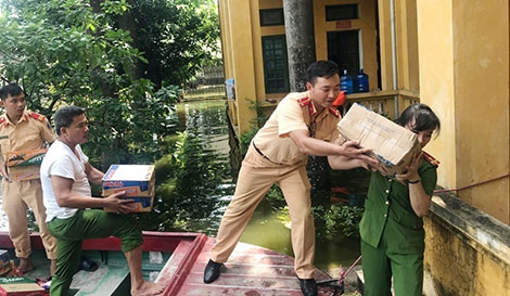 Cán bộ, chiến sỹ Công an huyện Chương Mỹ khẩn trương giúp đỡ cứu trợ người dân trong vùng lũ.