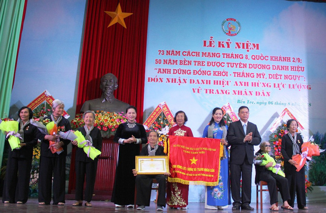 Chủ tịch Quốc hội Nguyễn Thị Kim Ngân và Bí thư Tỉnh ủy Bến Tre Võ Thành Hạo thay mặt Đảng và Nhà nước trao tặng danh hiệu Anh hùng Lực lượng vũ trang nhân dân cho “Đội quân tóc dài” Bến Tre.