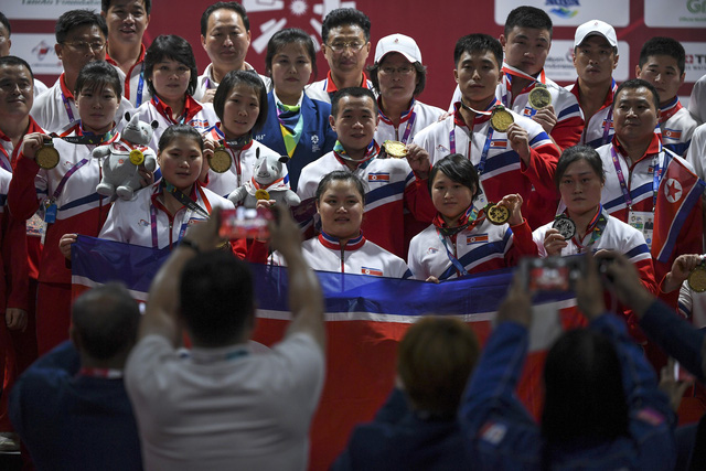 Các vận động viên cử tạ Triều Tiên chụp ảnh chung sau khi giành huy chương ở ASIAD (Ảnh: AFP)