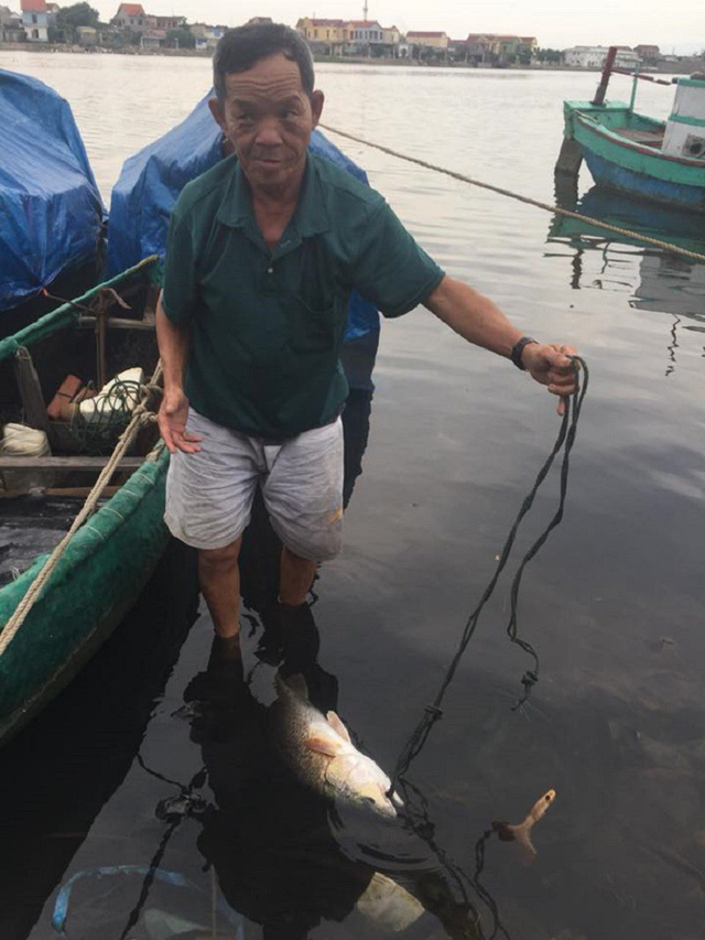 Ngư dân Nguyễn Lộc cùng với con cá vừa bắt được