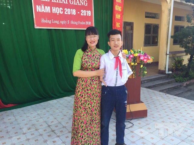 Hưng chụp ảnh cùng cô giáo chủ nhiệm Trần Thị Hòa trong ngày khai giảng năm học mới