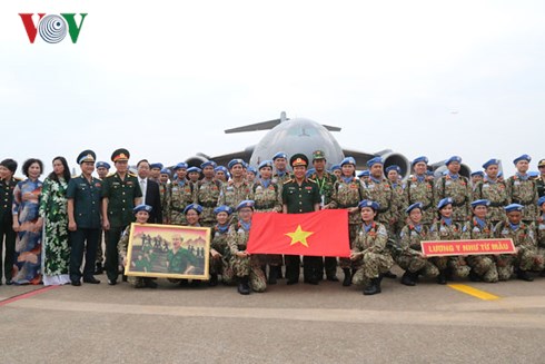 Đoàn cán bộ quân y Bệnh viện dã chiến Việt Nam chụp hình lưu niệm với lá cờ Tổ quốc trước máy bay vận tải C-17 trước giờ sang Nam Sudan.