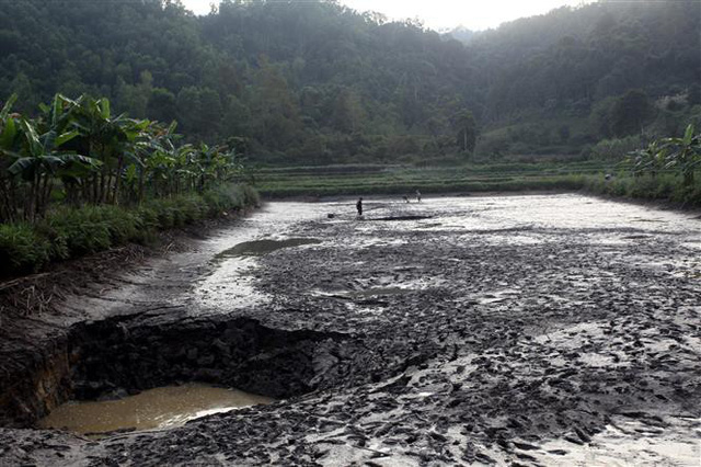 Hố sụt l&uacute;n  "h&uacute;t " cạn cả nước lẫn c&aacute;. Ảnh: Đức Hiếu - TTXVN