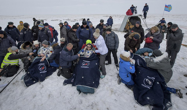 T&igrave;nh nguyện vi&ecirc;n chăm s&oacute;c c&aacute;c phi h&agrave;nh gia l&uacute;c trở về - Ảnh: AFP