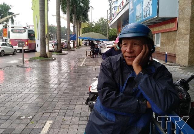 Nét khắc khổ trên gương mặt một tài xế xe ôm đag đợi khách dưới trời mưa rét.