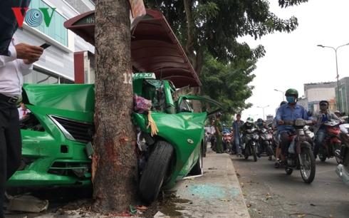 Chiếc taxi sau khi va chạm với hai ô tô khác, tông qua nhà chờ xe buýt đã lao vào gốc cây.
