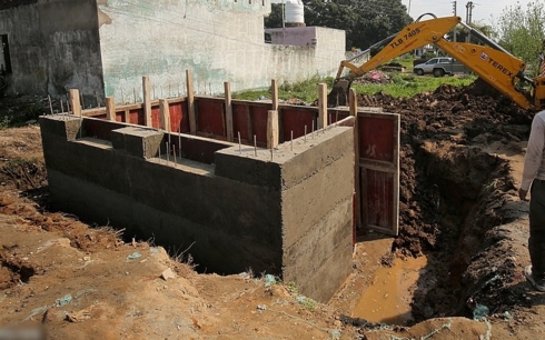 Công nhân xây một hầm bê tông tại khu dân cư gần biên giới với Pakistan. Nhiều người dân dọn dẹp hầm cũ còn những người khác thì xây hầm mới. Ảnh: Reuters.