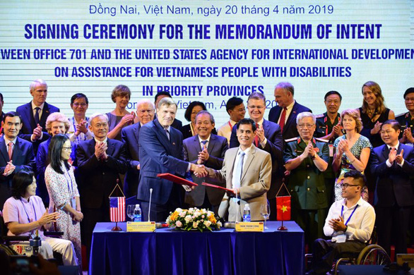Phái đoàn Mỹ và đại diện các cơ quan, ban ngành Việt Nam ký bản ghi nhận ý định về quan hệ đối tác mới để hỗ trợ người khuyết tật ngày 20-4 - Ảnh: QUANG ĐỊNH