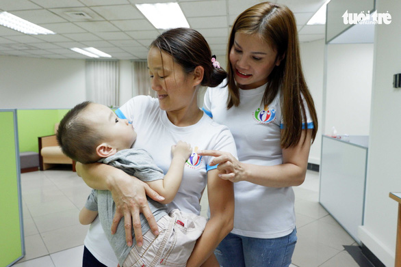 Chị Nguyễn Thị Thảo Hương (phải) thăm hỏi hai mẹ con bé Đinh Trung Kiên trong chuyến về Việt Nam gần đây - Ảnh: K.ANH