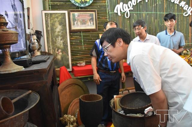 Chủ tịch UBND tỉnh tìm hiểu về chiếc trạn bát dùng hàng ngày của người dân vùng núi tại gian trưng bày của huyện Ngọc Lặc.