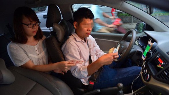 Hành khách đi xe GrabCar - Ảnh: TL