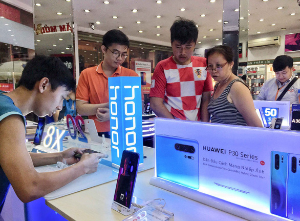 Khách hàng tìm hiểu điện thoại Huawei tại một hệ thống siêu thị ở TP.HCM - Ảnh: DUYÊN PHAN