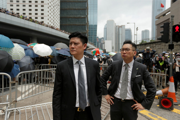 Hai nhà lập pháp Jeremy Tam và Alvin Yeung đến từ Đảng Công dân Hong Kong đứng quan sát khi người biểu tình chiếm giữ các con đường của Hong Kong sáng 12-6 - Ảnh: REUTERS