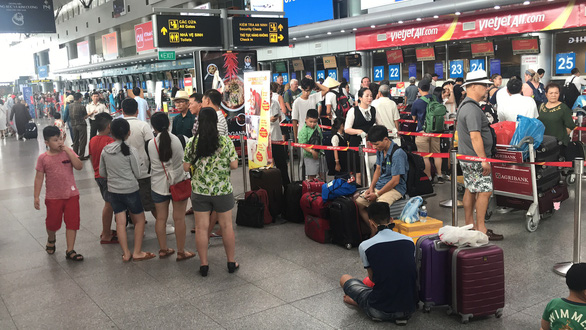 Hành khách tập trung trước quầy của hãng VietJet tại sân bay Đà Nẵng - Ảnh: TRƯỜNG TRUNG