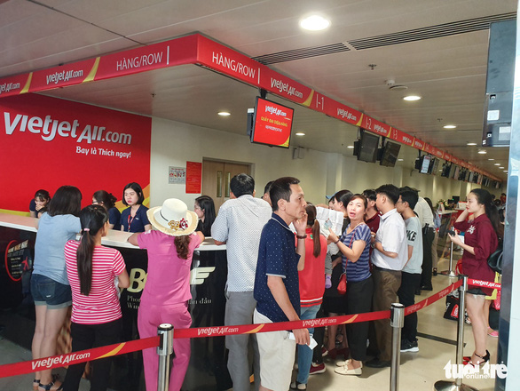 Hành khách làm thủ tục nhận bồi thường chậm chuyến bay của Vietjet sáng 16-6 tại sân bay Tân Sơn Nhất - Ảnh: C.TRUNG