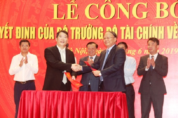 Bộ trưởng Bộ Tài chính Đinh Tiến Dũng (giữa) trao quyết định và tặng hoa chúc mừng ông Cao Anh Tuấn được bổ nhiệm giữ chức Tổng cục trưởng Tổng cục Thuế (Ảnh: KT)