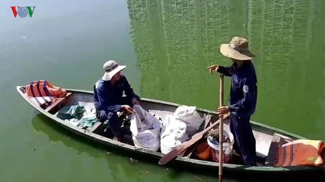 Công nhân môi trường dùng khoáng hóa vệ sinh nước tại hồ cá chết (Ảnh: Hà Nam).