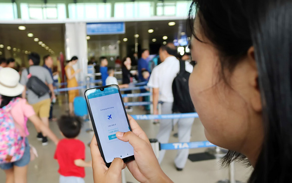 Khách hàng tìm hiểu ứng dụng trên điện thoại về bảo hiểm “delay” nếu xảy ra tình trạng trễ giờ, hủy chuyến bay - Ảnh: NGỌC PHƯỢNG