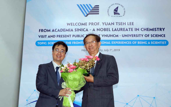 TS Trần Minh Triết - phó hiệu trưởng Trường ĐH Khoa học tự nhiên, ĐH Quốc gia TP.HCM - trao tặng hoa cảm ơn GS Yuan Tseh Lee (phải) khi chia sẻ cùng sinh viên nhà trường - Ảnh: TRỌNG NHÂN