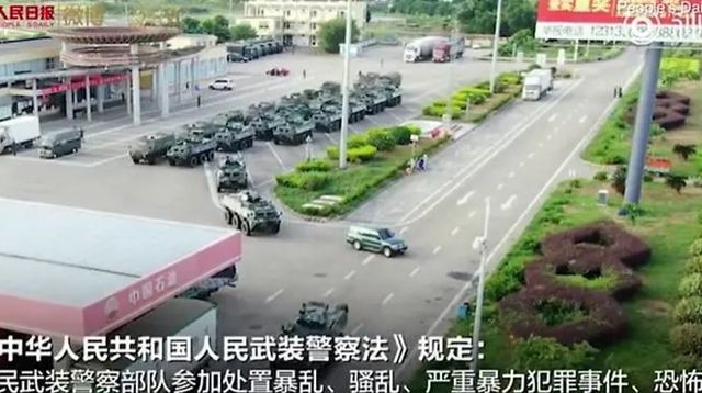 Ảnh cắt từ video cho thấy các phương tiện bọc thép xuất hiện gần biên giới Hong Kong (Ảnh: CNA)