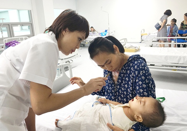  TS.BS Lê Diệp Linh, Phó Giám đốc Trung tâm Phẫu thuật sọ mặt và tạo hình, BV Trung ương Quân đội 108 thăm khám và tư vấn cho trẻ sau mổ.