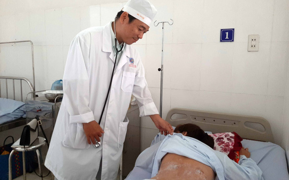 Bác sĩ khám cho nữ bệnh nhân bị phỏng cồn khi giác hơi - Ảnh: T.LŨY