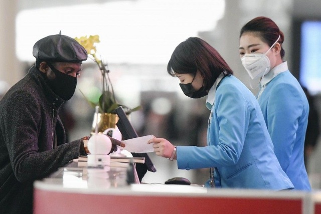 Nhân viên kiểm tra hành khách tại sân bay quốc tế Bắc Kinh ngày 27/1. (Nguồn: Kyodo News)