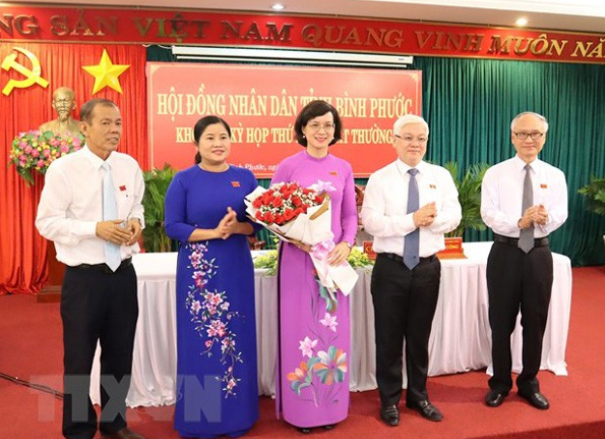 Lãnh đạo tỉnh Bình Phước tặng hoa chúc mừng bà Trần Tuyết Minh (người ôm hoa)
