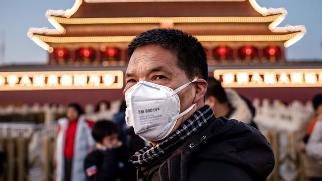 Một người đàn ông đeo khẩu trang đứng trước cổng Thiên An Môn ở thủ đô Bắc Kinh, Trung Quốc (Ảnh: AFP)