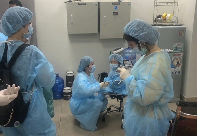 Các nhân viên y tế kiểm soát một du khách bị sốt tại Cảng hàng không quốc tế Cam Ranh. - Ảnh: TNO