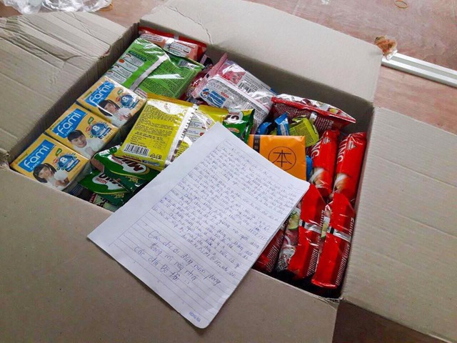 Kèm theo lá thư là một thùng đồ ăn vặt được xếp gọn gàng làm quà tặng cho những người cách ly.