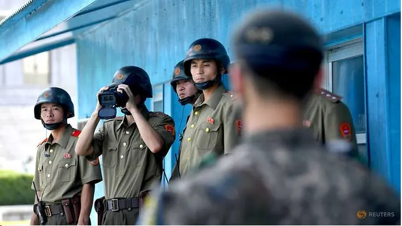 Binh sĩ Triều Ti&ecirc;n nh&igrave;n về l&agrave;ng đ&igrave;nh chiến B&agrave;n M&ocirc;n Điếm b&ecirc;n trong khu phi qu&acirc;n sự ở bi&ecirc;n giới li&ecirc;n Triều. Ảnh: Reuters.