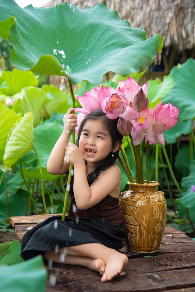 Em bé thích thú khi chụp ảnh ở hồ sen. Nhiếp ảnh gia Nguyễn Hiếu.