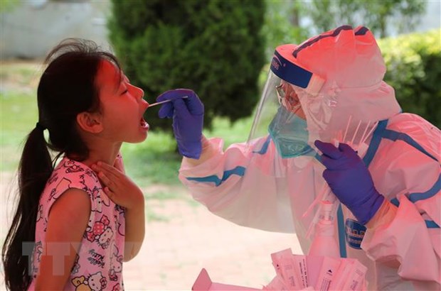 Nhân viên y tế lấy mẫu xét nghiệm COVID-19 cho người dân tại một điểm xét nghiệm dã chiến ở thành phố Đại Liên, tỉnh Liêu Ninh, Trung Quốc ngày 28/7/2020. (Nguồn: AFP/TTXVN)