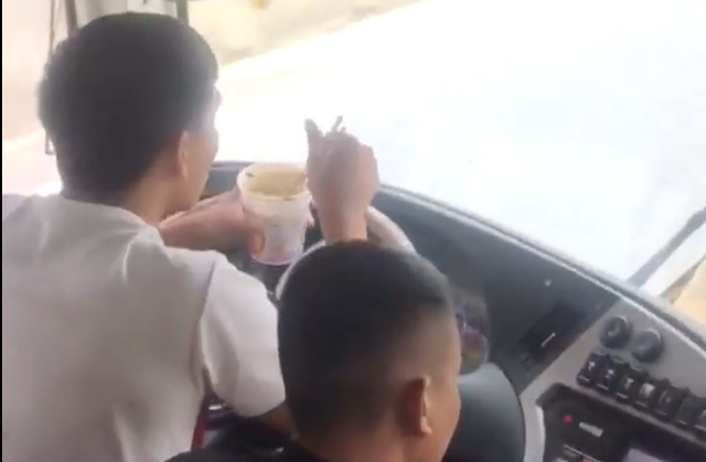 H&igrave;nh ảnh t&agrave;i xế vừa l&aacute;i xe kh&aacute;ch giường nằm chở h&agrave;ng chục người vừa ăn mỳ t&ocirc;m. (Ảnh cắt từ clip)