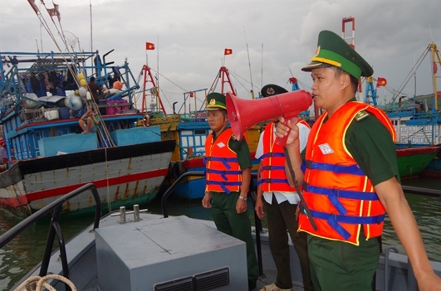 Cán bộ Đồn Biên phòng cửa khẩu cảng Quy Nhơn kêu gọi tàu thuyền tránh trú bão. Ảnh: Báo Biên phòng