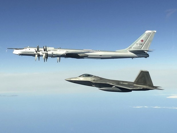 Máy bay ném bom Tu-95 của Nga (trên) và tiêm kích F-22 Raptor của Mỹ. (Ảnh: North American Aerospace Defense Command/AP)
