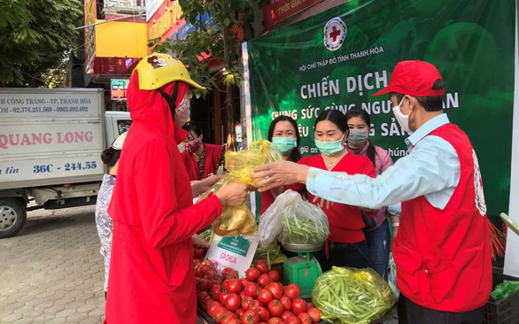 Người dân TP Thanh Hóa mua rau củ quả giải cứu nông sản cho bà con nông dân tỉnh Hải Dương tại trụ sở Hội Chữ thập đỏ tỉnh Thanh Hóa - Ảnh: BÌNH AN
