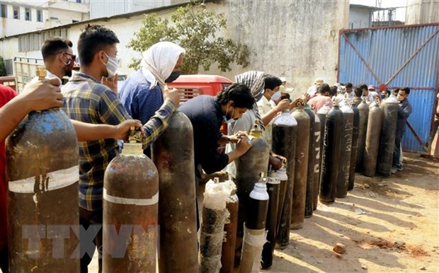 Người dân xếp hàng chờ bơm đầy bình oxy để cung cấp cho bệnh nhân COVID-19 tại Patna, Ấn Độ, ngày 27/4/2021. (Ảnh: THX/TTXVN)