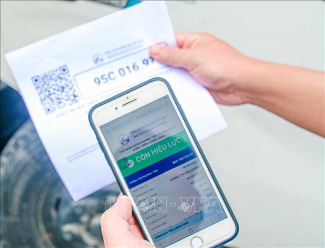 Kiểm tra mã QR luồng xanh của một xe tải vận chuyển hàng vào thành phố Cần Thơ. Ảnh: Thanh Liêm/TTXVN