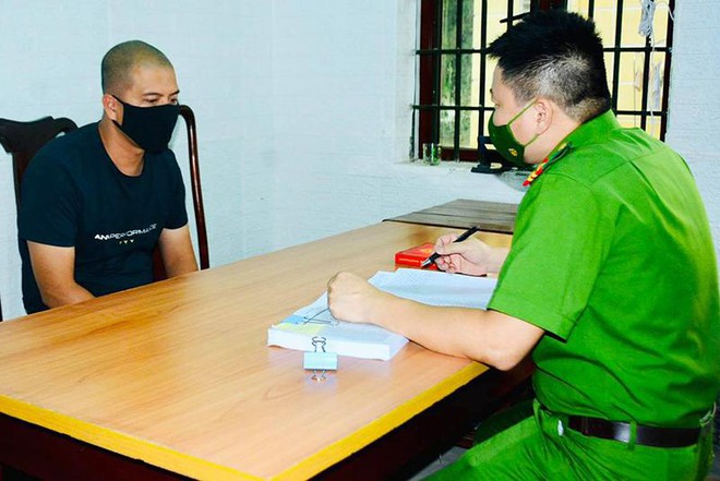 Cán bộ điều tra ghi lời khai đối tượng Trần Ngọc Linh (áo phông đen)