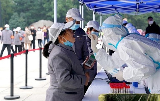 Nhân viên y tế lấy mẫu xét nghiệm Covid-19 cho người dân tại tỉnh Thiểm Tây, Trung Quốc. (Ảnh: THX/TTXVN)