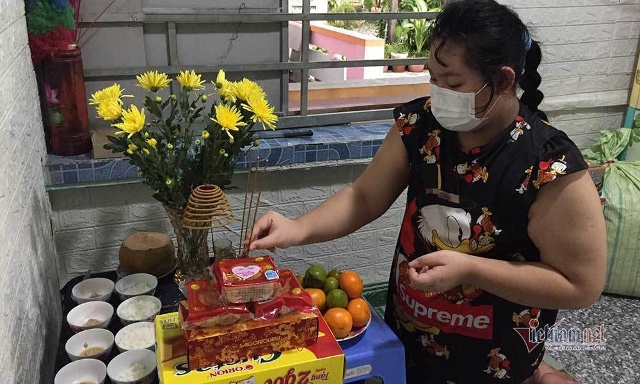 Bé Nguyễn Thị Mai Khanh bên bàn thờ cha mẹ