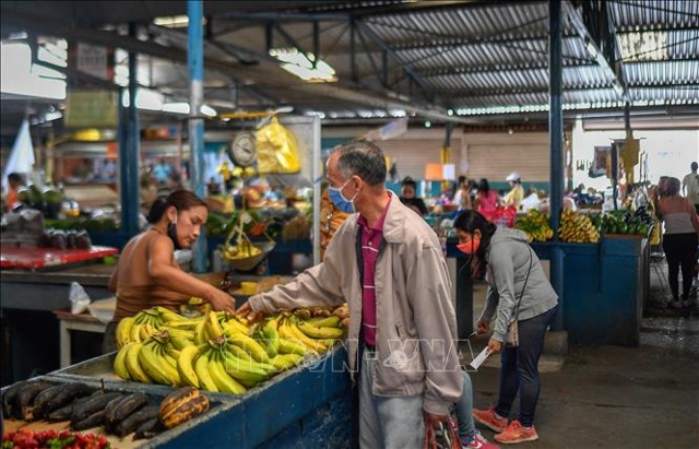 Người dân mua sắm tại chợ ở Caracas, Venezuela. Ảnh: AFP/TTXVN