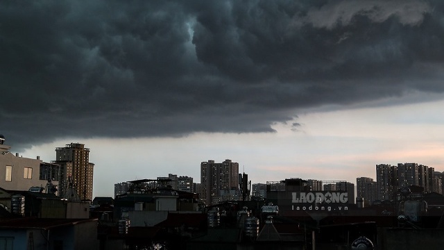 Bầu trời khu vực nội thành Hà Nội tối sầm, kèm theo mưa dông và gió giật mạnh. Ảnh minh hoạ: Quang Minh.
