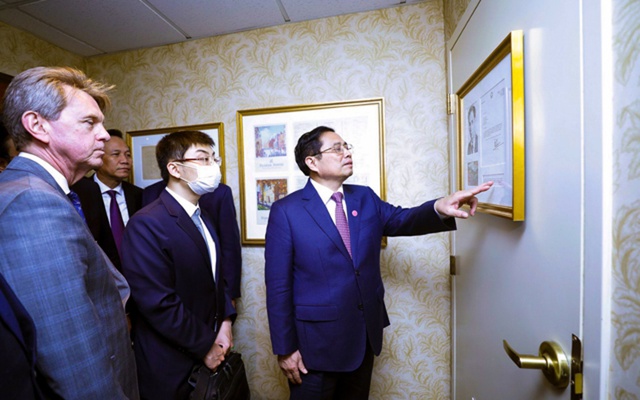 Thủ tướng Phạm Minh Chính xem hình ảnh tư liệu về Chủ tịch Hồ Chí Minh được trưng bày tại khách sạn Omni Parker House. (Ảnh: Dương Giang/TTXVN)